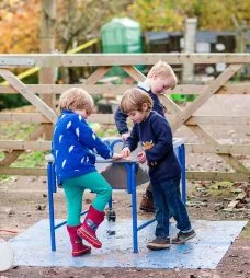 Two children at a table in the outdoor area